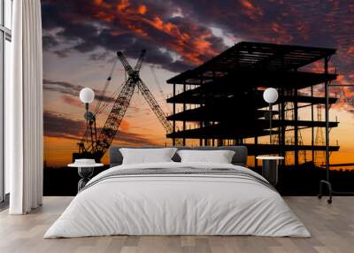 Steel construction site at sunset with a crane. Wall mural