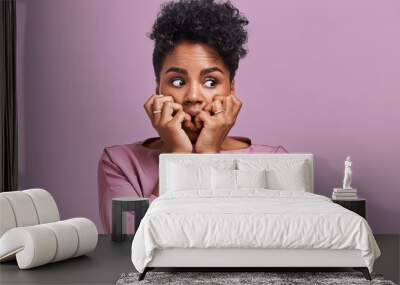 Emotions concept. Nervous emotional scared young lovely African American female stares at camera and opens mouth widely, notices phobia, expresses her fear against something, poses alone indoor Wall mural