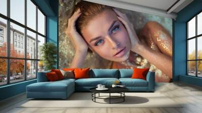 very beautiful woman with incredible blue eyes lies on the golden sand. Sensual portrait of amazing girl wet hair. Tan beach vacation spa. Sexy model portrait close-up. Glamor sparkles on body Wall mural