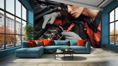 67 Mechanic A woman inspecting the engine of a car her face clos Wall mural