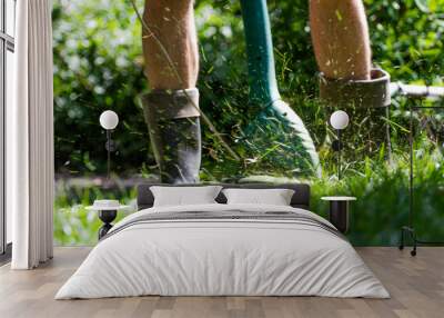 A man mows the lawn with a trimmer Wall mural