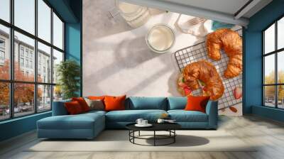 Breakfast table. On a white tablecloth, two ruddy croissants with fresh strawberries, milk. Decor - indoor flower. Bright sunlight. Romantic breakfast, date, Valentine's Day. Restaurant, hotel. Wall mural