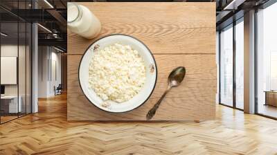 Cottage cheese with milk in a bowl on a wooden table Wall mural