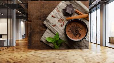 cup of hot chocolate, cinnamon sticks, mint and chocolate on wooden table Wall mural