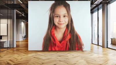 Children model on a white background.  Little girl with long hair, wearing a red hoodie Wall mural