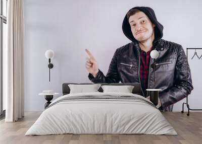 Man in trendy jacket on white background. Portrait of young male in leather jacket zipping up and smiling at camera on white background Wall mural