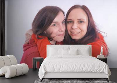 two friends or lesbians on a white background, smiling and laughing in the company of each other. The concept of female friendship and love Wall mural