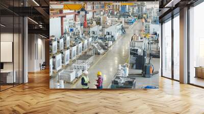 Engineers in hard hats working at the industrial plant. Wall mural