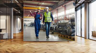 Engineers walking along the plant they work at shot from distance. Wall mural