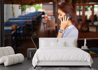 Portrait of female restaurant manager. Businesswoman work with laptop and mobile phone in cafe. Wall mural