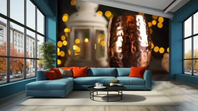 Golden cup with coffee or tea on a background of lamps and night lights. Nightly atmosphere, fashion and love of coffee, hot chocolate or tea drinking Wall mural