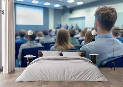 Diverse group of people attentively listening to speakers during a business seminar in modern conference room setting Wall mural