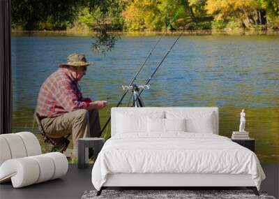 Senior fisherman catches a fish Wall mural