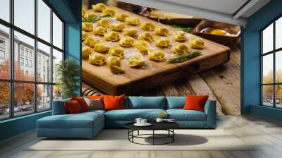 Homemade ravioli, dumplings stuffed with minced meat on a cutting board, wooden background. The process of making homemade dumplings, ravioli. Wall mural