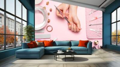 Nail care. beautiful women hands making nails painted with pink gentle nail polish on a pink background. Women's hands near a set of professional manicure tools. Beauty care Wall mural