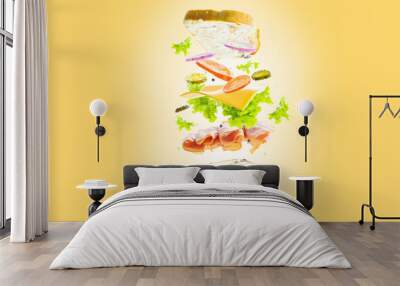 On a yellow background, a sandwich with pieces of meat, vegetables, cheese, herbs in a frozen flight. Creative composition. Minimalism. There are no people in the photo. Wall mural