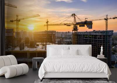 Construction site with cranes at sunset. Construction of an apartment building Wall mural