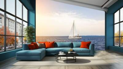 Yacht sailing at sunset during a storm. Luxury vacation at sea Wall mural