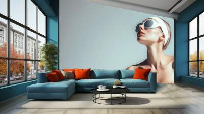 Stylish woman in futuristic sunglasses looking up Wall mural