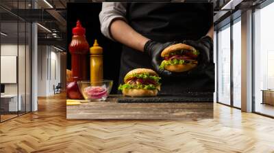 the chef prepares a burger, a hamburger. on a background with ingredients. Delicious and fast food, fast food. A menu, a cafe, fast food, catering, gastronomy Wall mural