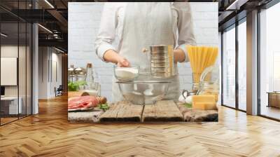 The chef prepares the dough working with flour, baking pasta or pizza, bread. On the background of light hay. Recipe book, baking shop, culinary recipes Wall mural