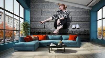 woman sitting on stairs with running shoes Wall mural