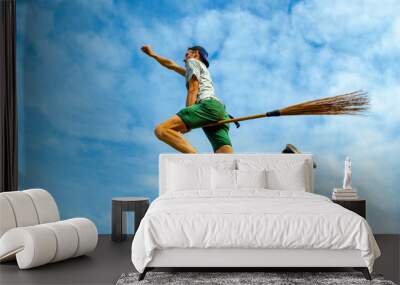 Young man outstretched arm flying on the broom in the blue sky of Siquijor Wall mural