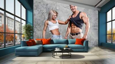 Beautiful young sporty sexy couple men and a woman posing Wall mural