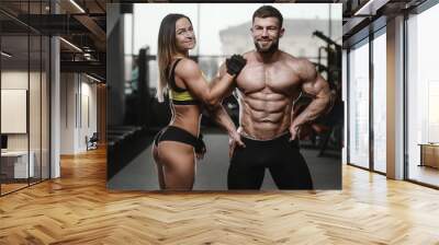 Model young man and woman working out in gym Wall mural