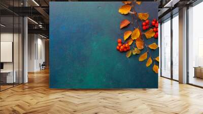 Two branches of autumn leaves (Spiraea Vanhouttei) and small red fruits Rowans on a dark blue-green painted wooden background. Wall mural