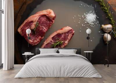 top view of fresh raw beef loin, with salt and a sprig of rosemary on wooden background. Wall mural