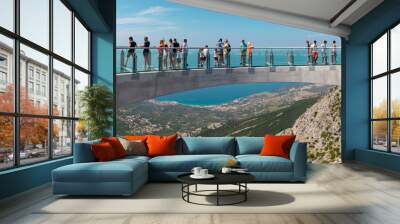 Tourists walking accross the newly built skywalk on Biokovo mountain. Wide view from the entrance, towns and the sea visible in far distance Wall mural