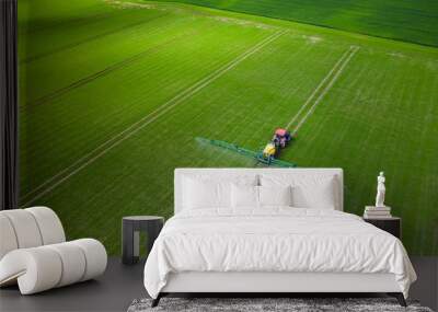 Tractor cultivating green field Wall mural