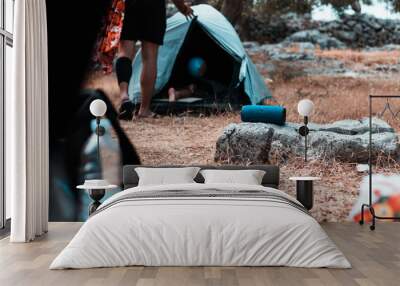 Wireless speaker standing on a rock outside, tents around it, camping in the nature and listening to music Wall mural