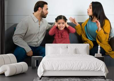 Annoyed young daughter in the middle of her parents fight Wall mural