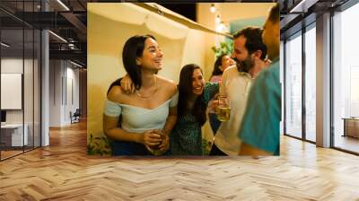 Attractive happy friends drinking alcohol having fun Wall mural