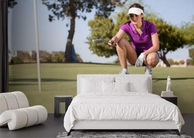 Beautiful female golfer planning how to get the ball in Wall mural