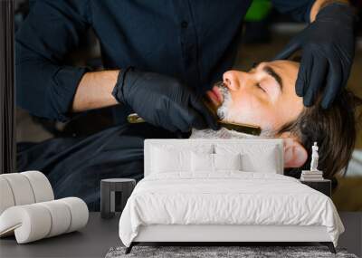 Caucasian client relaxing while getting a beard shave Wall mural