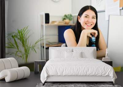 Confident and professional woman entrepreneur smiling at her desk in a bright startup office with copy space Wall mural