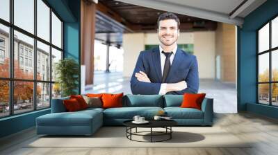 Confident Young Executive In Suit Smiling Outside Workplace Wall mural