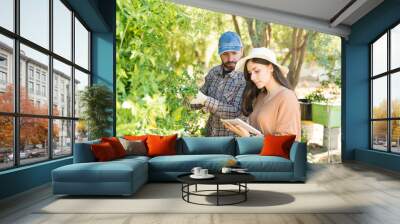 Couple Examining Plants With Digital Tablet In Garden Wall mural