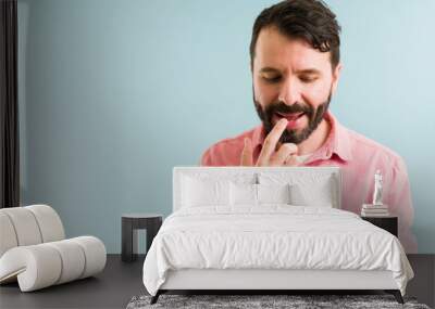 Handsome latin man applying lip balm Wall mural