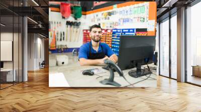 Happy hardware store employee at the computer desk at work Wall mural