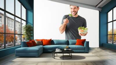 Healthy young latin man holding his green salad and fork Wall mural