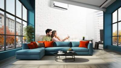 Latin Couple Watching TV At Home Wall mural