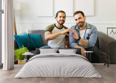 Lovely gay couple in love forming a heart with their hands Wall mural