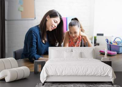 Mother Assisting Daughter With Schoolwork At Table Wall mural