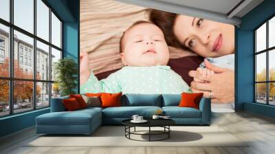 Newborn baby lying in bed with mom Wall mural