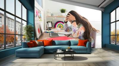 Overwhelmed teen girl with a headache holding her head Wall mural