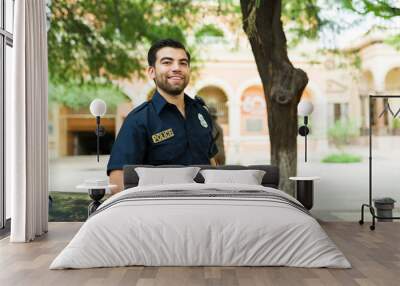 Portrait of a happy male cop leaning into the police car Wall mural